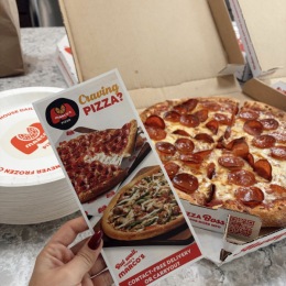 a hand holding a pizza menu